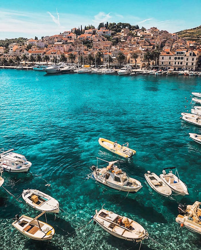 Home Boats in the vibrant blue waters of Hvar, Croatia, showcasing a charming coastal town under sunny skies.